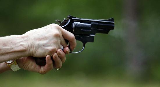 Mujer apuntando un arma
